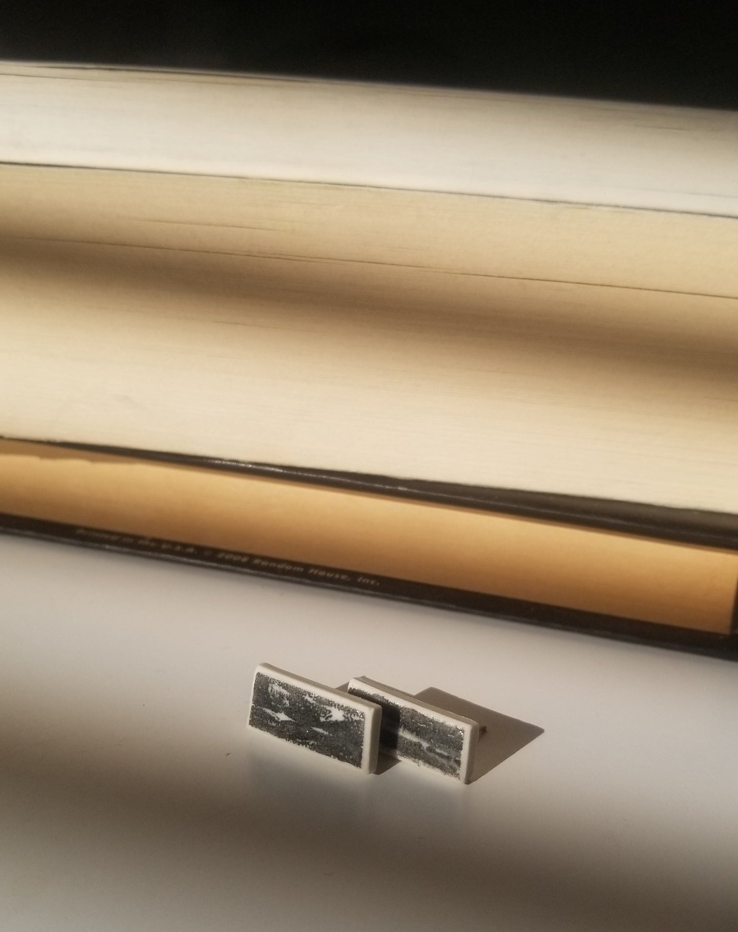 Black printed rectangle studs close up. Handmade porcelain jewelry.