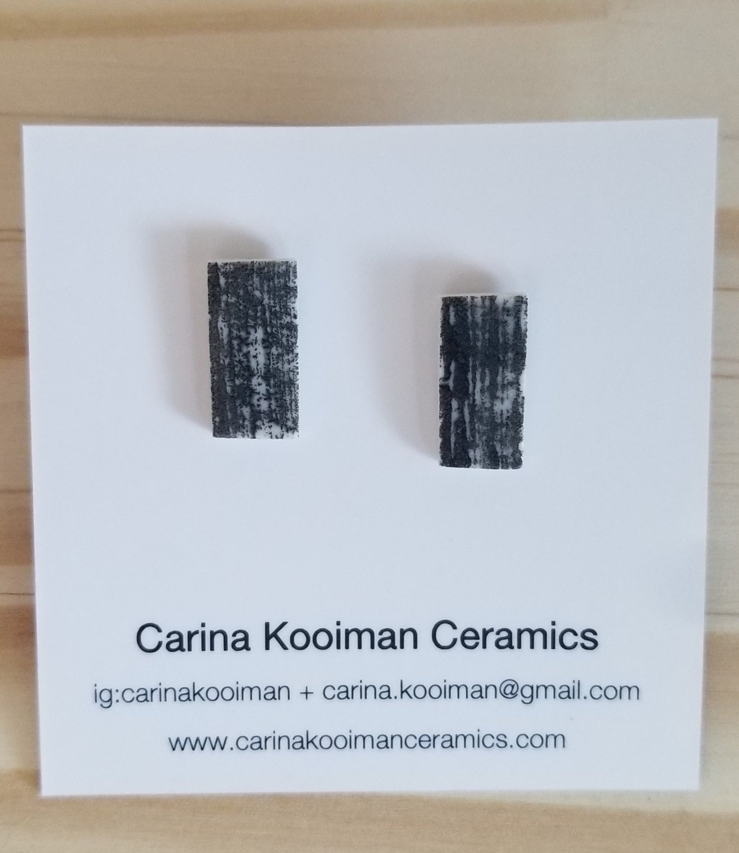 Black printed rectangle studs on jewelry card. Handmade porcelain jewelry.